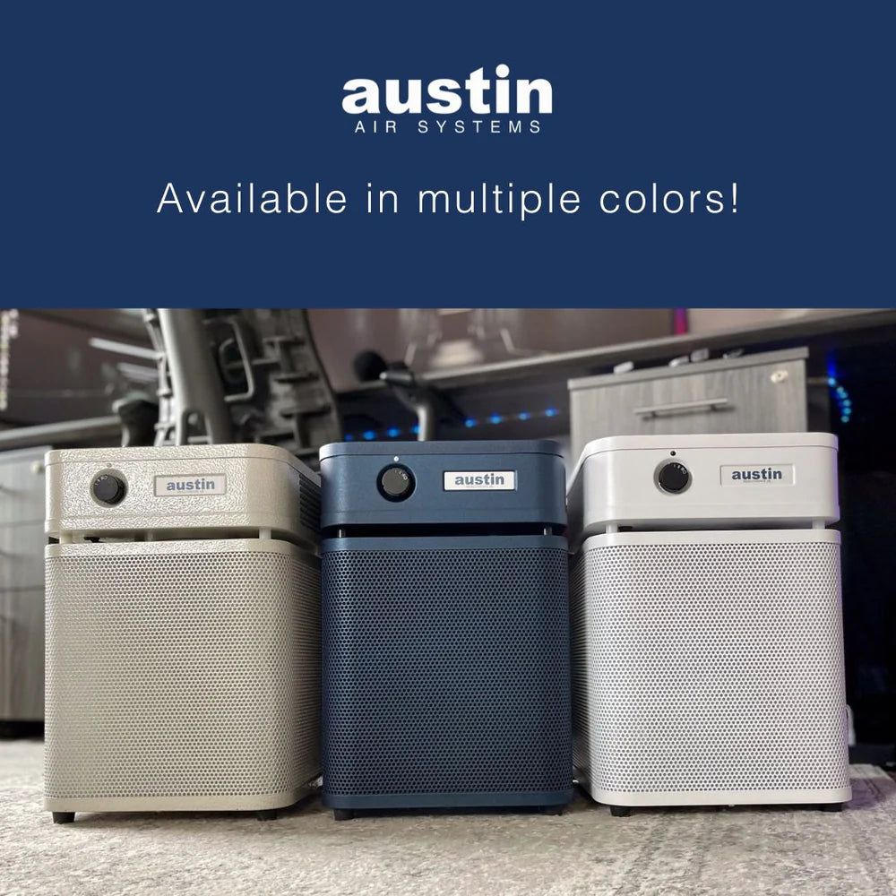 Three air purifiers from Austin Air Systems on a carpeted floor with a blue background.