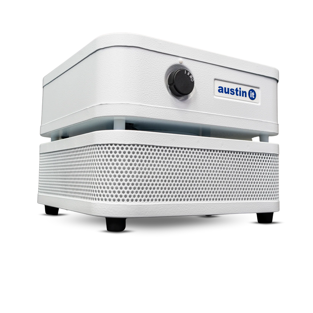 A white Austin air purifier with a perforated front grille, a top control unit with a black dial, and a blue and white Austin logo, shown on a clean white background.