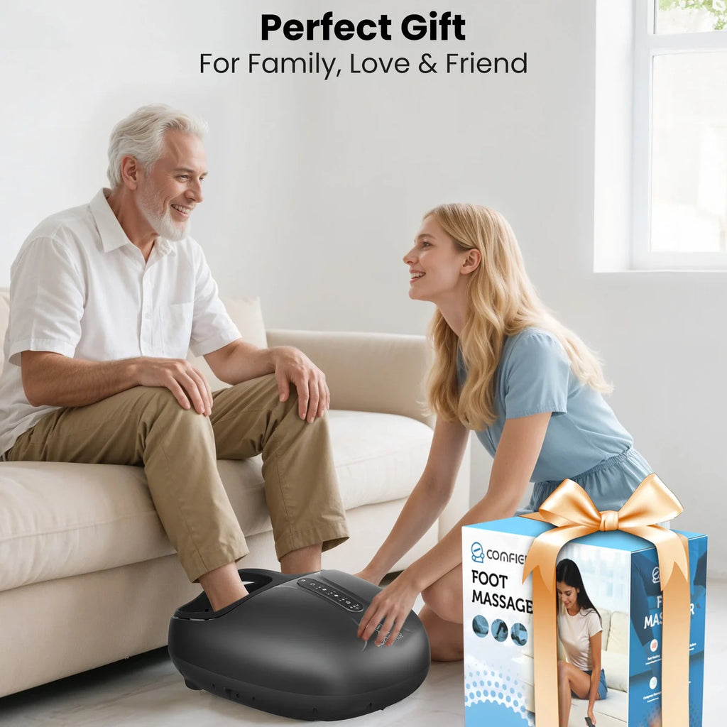 Man using a foot massage device with a woman beside him, and a gift box in the foreground.