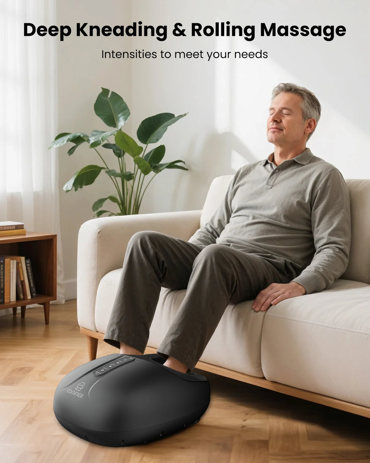 Man using a foot massager in a living room setting with a plant and books in the background.