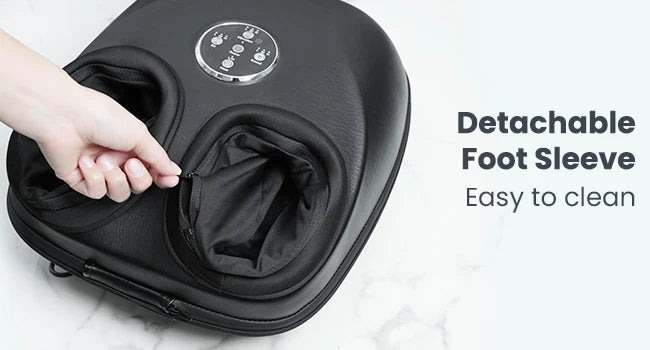 A black foot massager with a detachable foot sleeve being opened by a hand, shown on a light marble-like surface with text reading 'Detachable Foot Sleeve' and 'Easy to clean'.