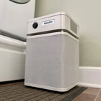 White air purifier with 'austin' branding on a carpeted floor.