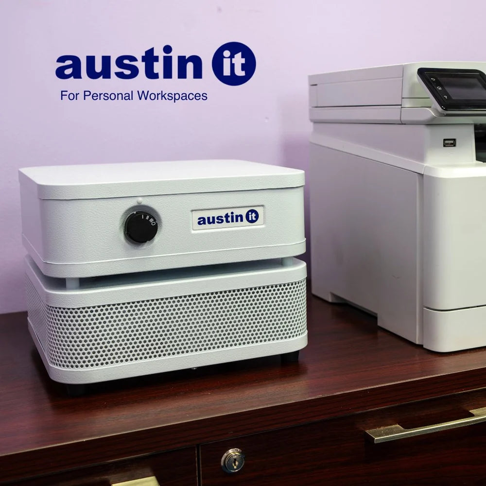 White electronic device with 'austin it' branding on a wooden surface against a light purple wall.