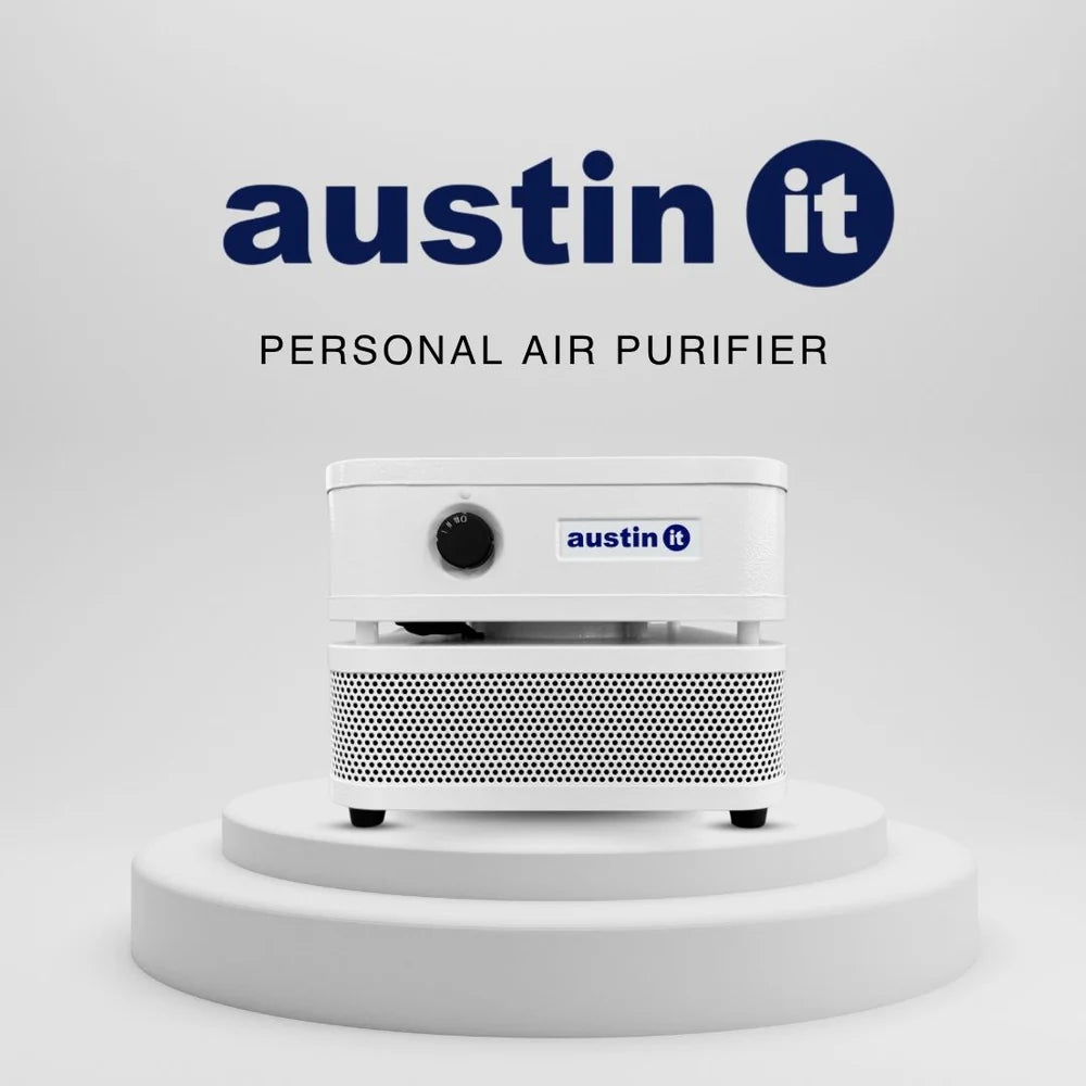 A white Austin It personal air purifier shown on a white tiered pedestal against a light gray background, with the Austin It logo and the words 'PERSONAL AIR PURIFIER' above it.