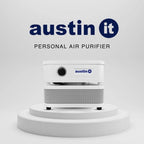 A white Austin It personal air purifier shown on a white tiered pedestal against a light gray background, with the Austin It logo and the words 'PERSONAL AIR PURIFIER' above it.