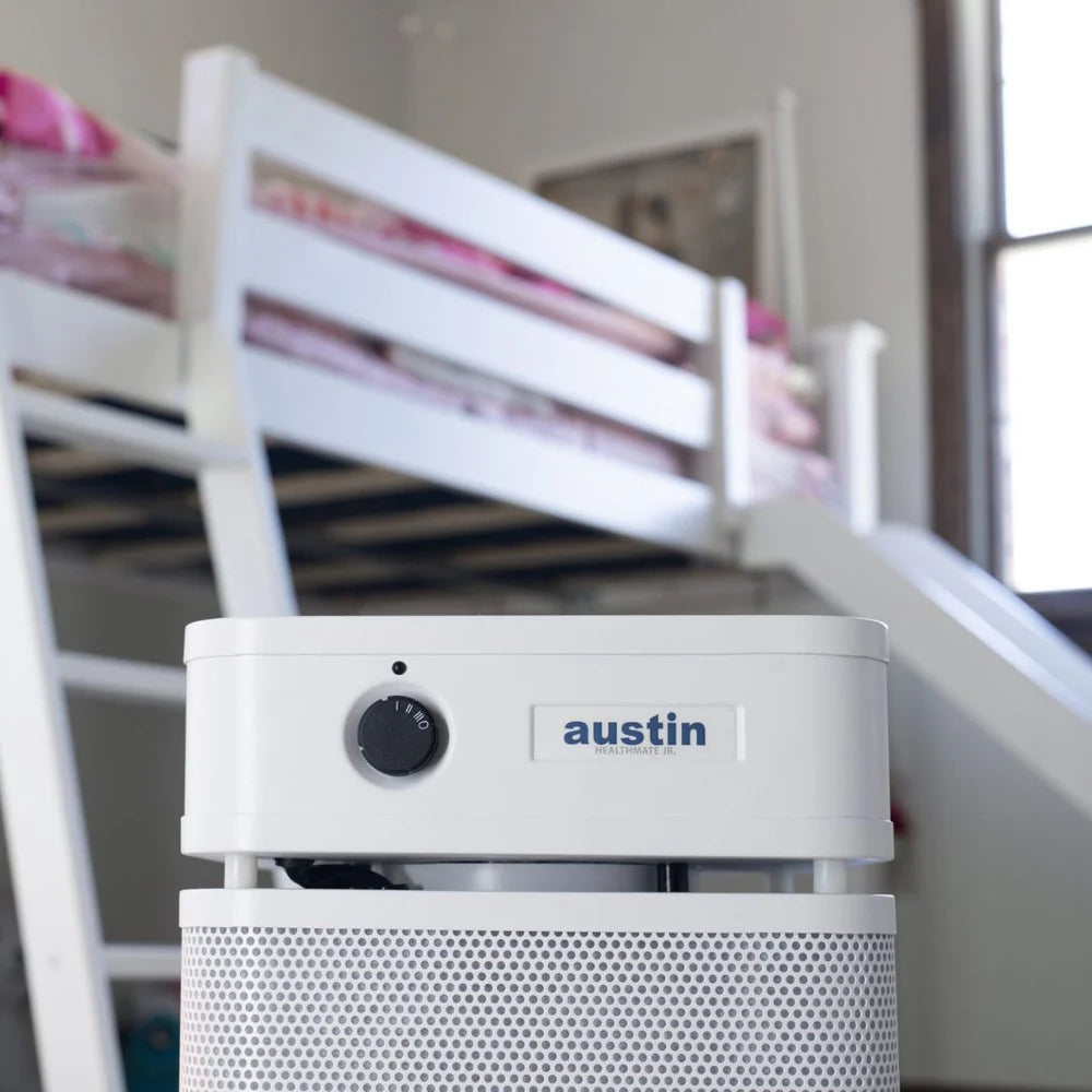 White air purifier with 'austin' branding in a room with bunk beds.