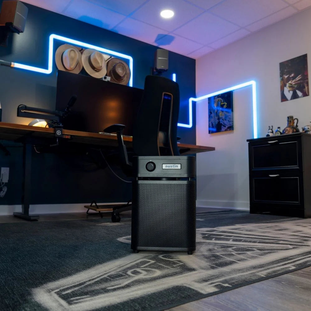 Modern home office with computer setup, neon lights, and decorative items.